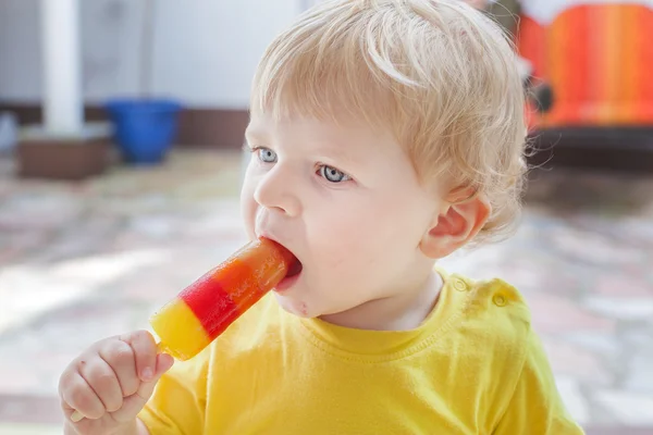 Menino pequeno comendo sorvete colorido — Fotografia de Stock