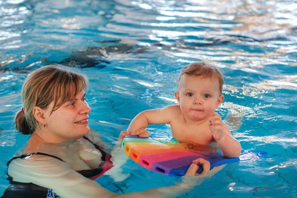 Bebé pequeno com olhos azuis aprendendo a nadar — Fotografia de Stock
