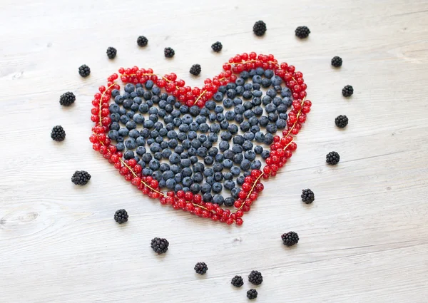 Coração feito com groselhas vermelhas e mirtilos — Fotografia de Stock