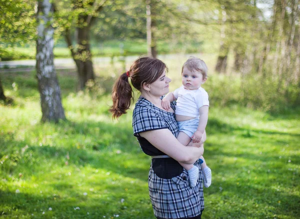 Happy young woman and baby boy in summer forest — Stock Photo, Image