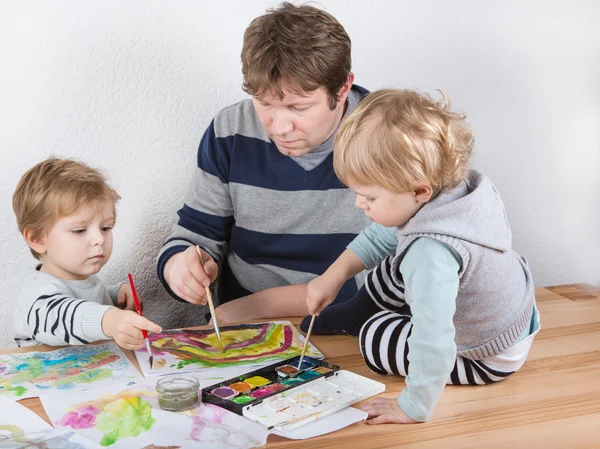 Père et deux petits garçons frères et sœurs s'amusent à peindre — Photo