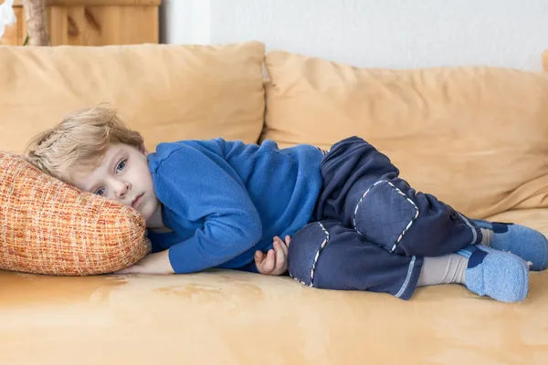 Cansado criança menino deitado no sofá — Fotografia de Stock