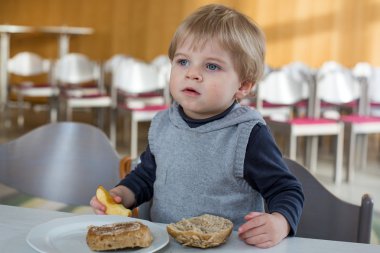 Anaokulunda yemek ekmek ve elma ile küçük çocuk