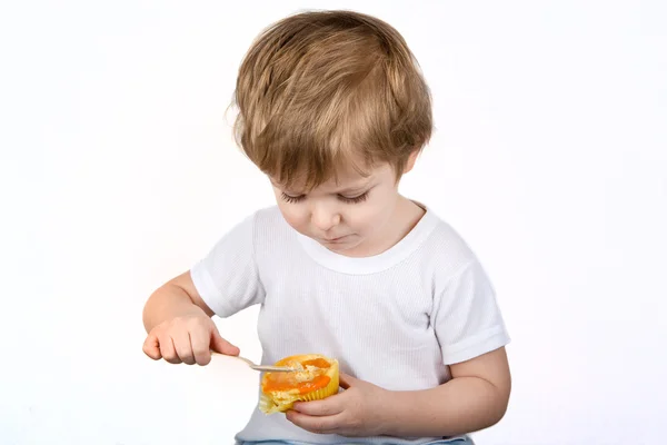 Little boy with eating cheesecake muffin. — Stock Photo, Image