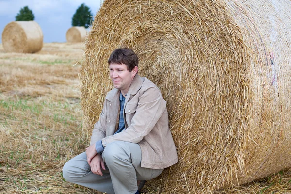 Young man on golden hay straw field in Germany — Stock Photo, Image