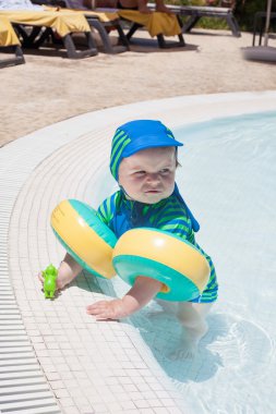 küçük havuzda oynarken oğlu