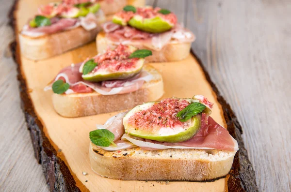 Crostini con fichi freschi, menta piperita e prosciutto — Foto Stock