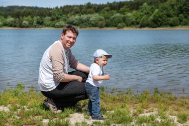 Yaz aylarında göl üzerinde yürümeye başlayan çocuğu olan genç adam
