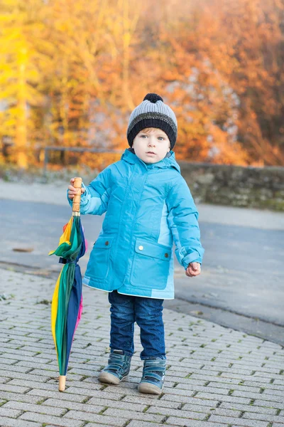 Mooie peuter jongen in blauwe kleren met paraplu — Stockfoto