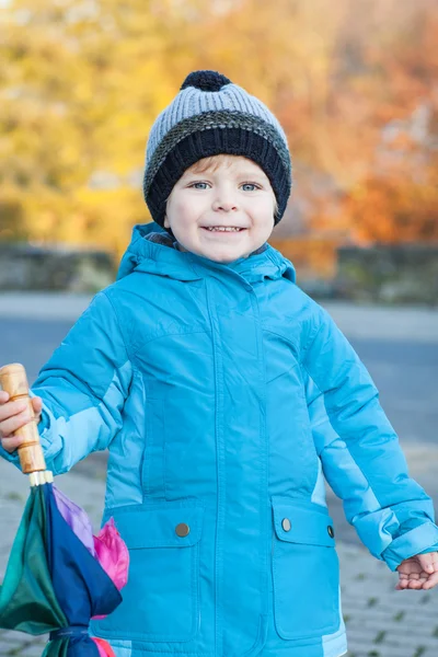 Hermoso niño en ropa azul con paraguas — Foto de Stock