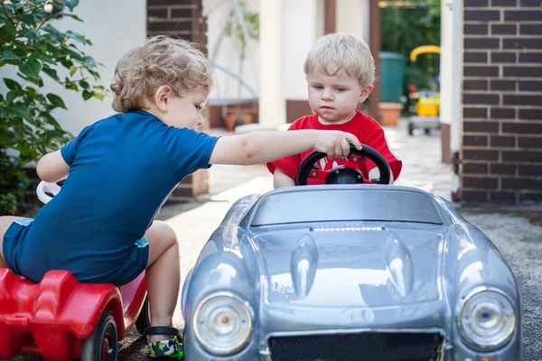 Dos hermanos pequeños jugando con coches — Foto de Stock