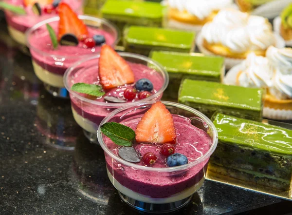 Різні види солодких десертних тортів з ягодами та зеленим чаєм — стокове фото