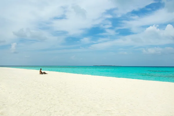 Young man on white sand beach on Maldives — Stock Photo, Image