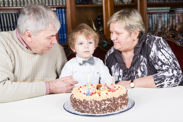 Kleine jongen viert zijn verjaardag thuis met zijn grootouder — Stockfoto