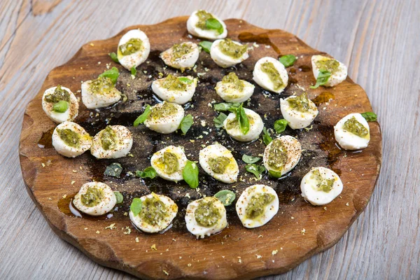 Mozzarella peyniri pesto, fesleğen ve zeytinyağı taşlarla — Stok fotoğraf