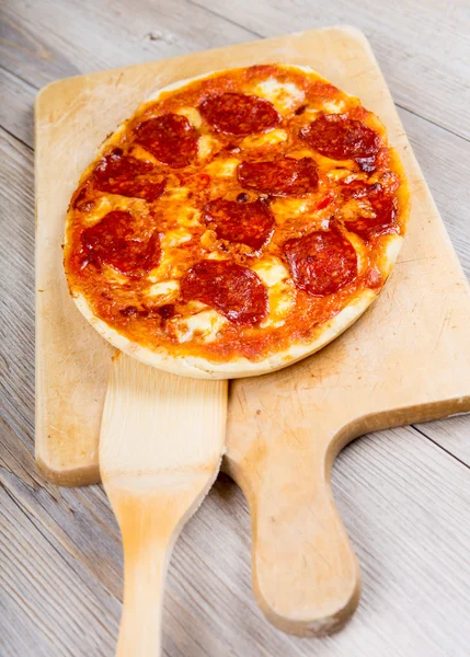 Pizza saborosa na placa de corte de madeira — Fotografia de Stock