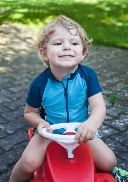 Liten todder pojke leker med stor leksaksbil — Stockfoto