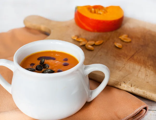 Sopa de crema vegetal de calabaza en tazón blanco con trozo de calabaza —  Fotos de Stock