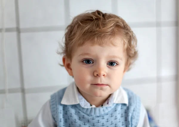 Красивый малыш с голубыми глазами в помещении — стоковое фото