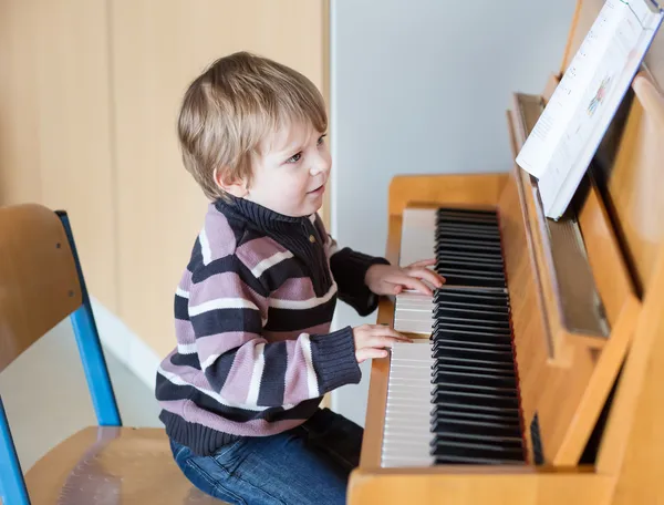 Iki yaşında yürümeye başlayan çocuk piyano — Stok fotoğraf