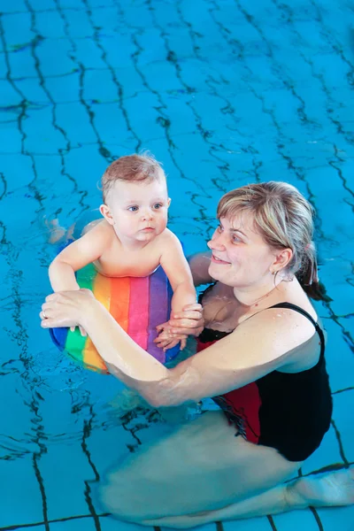 Małe dziecko o niebieskich oczach nauki pływania — Zdjęcie stockowe