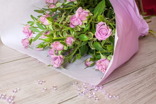 Букет з фіолетових троянд, прикрашений скляними краплями — стокове фото