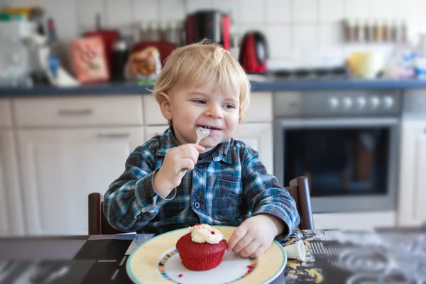 小さな男の子の食べる赤カップケーキ — ストック写真