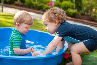 İki kardeş çocukları yaz aylarında su ile eğleniyor