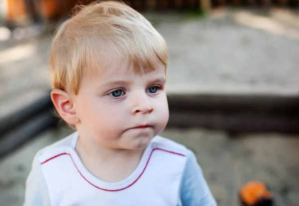 Pequeño niño jugando con arena y juguete — Foto de Stock