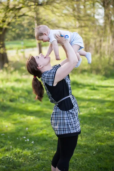 Ung mamma och söta baby boy i sommar skog — Stockfoto