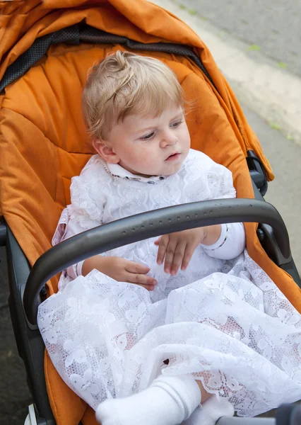 Dejlig baby dreng i varmt tøj efterår i orange klapvogn — Stock-foto ©  romrodinka #12589350