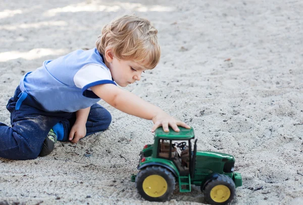 Menino criança brincando com areia e brinquedo — Fotografia de Stock