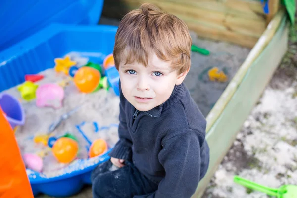 Kleiner Junge spielt mit Sand und Spielzeug — Stockfoto