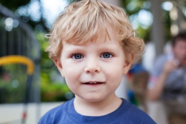 Sarı tüyleri olan küçük yürümeye başlayan çocuk portresi