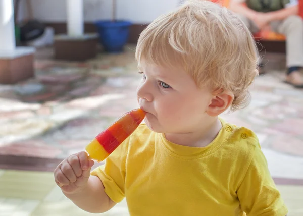 Menino pequeno comendo sorvete colorido — Fotografia de Stock