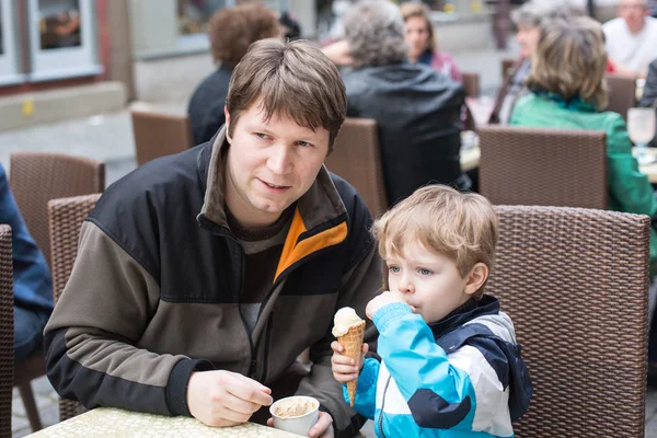 Young father and little boy eating ice cream