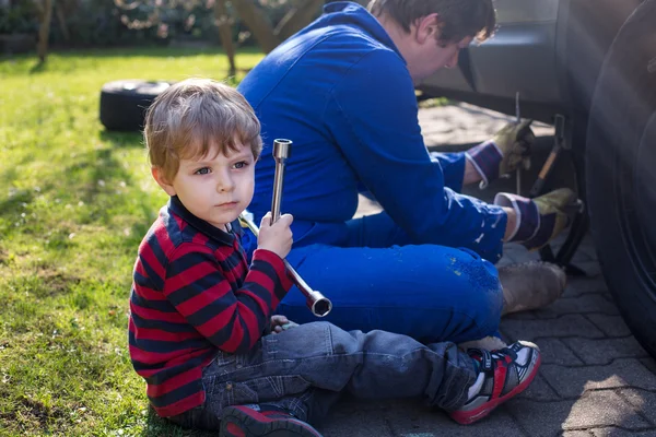 Little boy and his father changing wheel on car — Stock Photo, Image