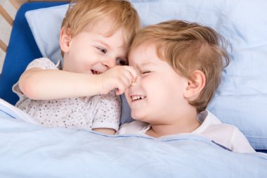 iki küçük yürümeye başlayan çocuk yatakta eğleniyor