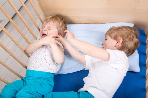 Dois irmãos meninos se divertindo na cama — Fotografia de Stock