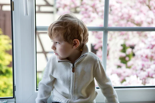 Adorable enfant regardant par la fenêtre — Photo