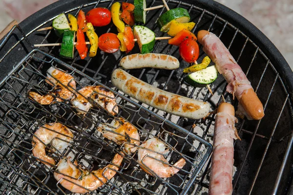 Worst, grote garnalen en plantaardige spiesjes roken op grill — Stockfoto
