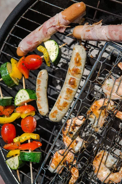 Worst, grote garnalen en plantaardige spiesjes roken op grill — Stockfoto