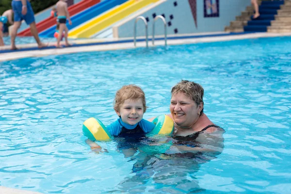 Grandmother and grandson swimming together in the pool — Stock Photo, Image