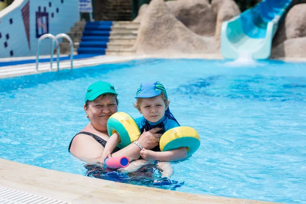 Babička a vnuk spolu plavání v bazénu — Stock fotografie