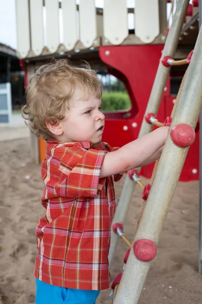 Oyun parkında oturan küçük yürümeye başlayan çocuk — Stok fotoğraf