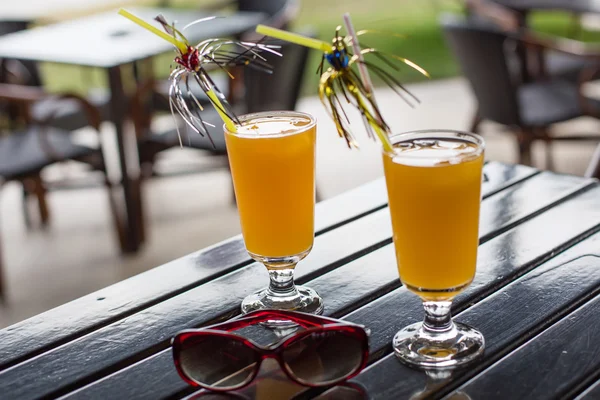 Yellow cocktail with straw on wood table — Stock Photo, Image