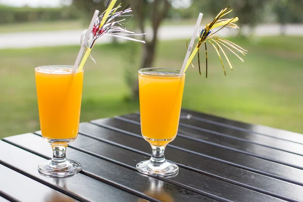 Gelber Cocktail mit Stroh auf Holztisch — Stockfoto