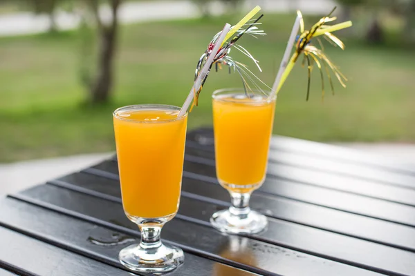 Yellow cocktail with straw on wood table — Stock Photo, Image