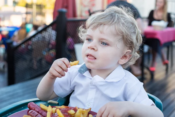 Lindo niño comiendo papas fritas en verano —  Fotos de Stock