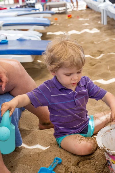 Pequeño niño jugando con arena y juguete — Foto de Stock